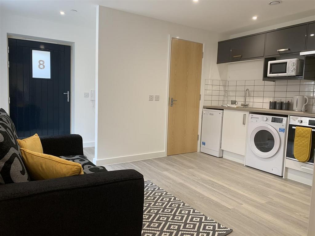 Modern open-plan living area with kitchenette...