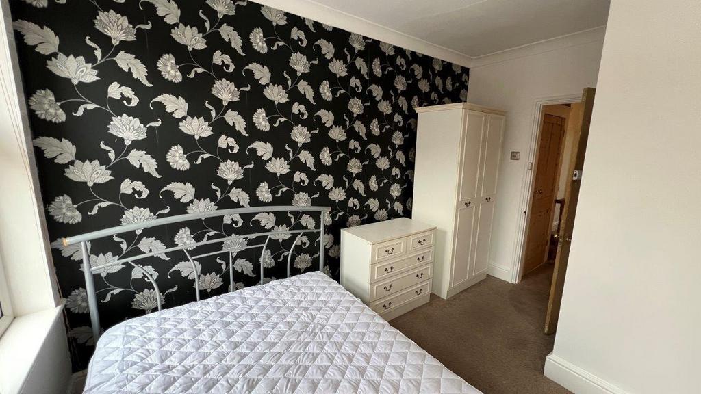 Bright double bedroom with patterned feature wa...