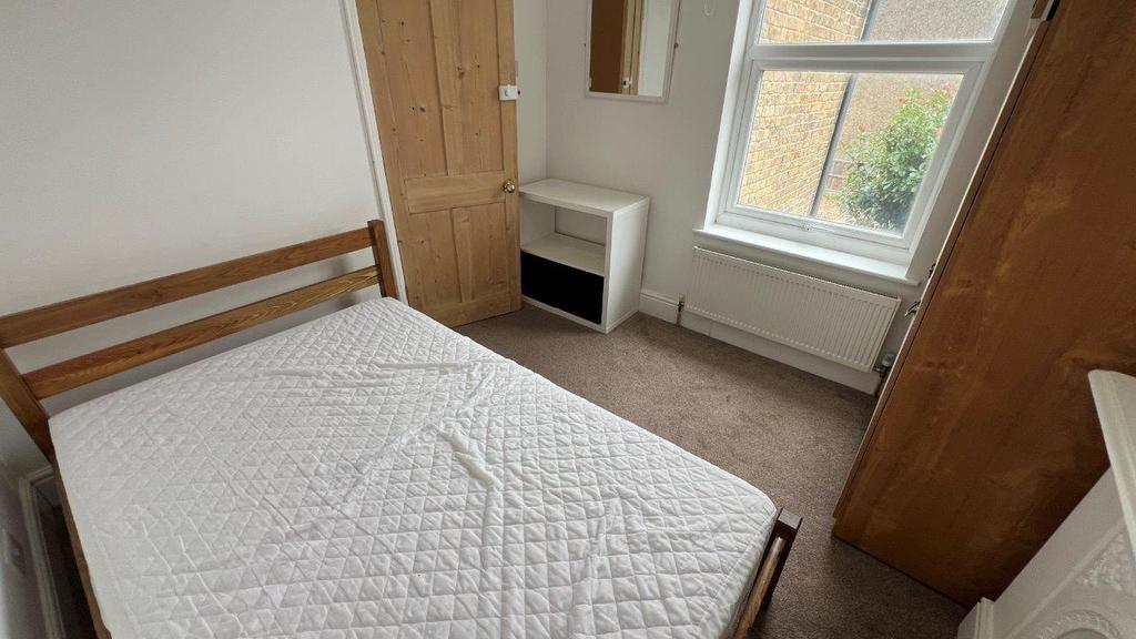 Bright bedroom with large window and wardrobe...