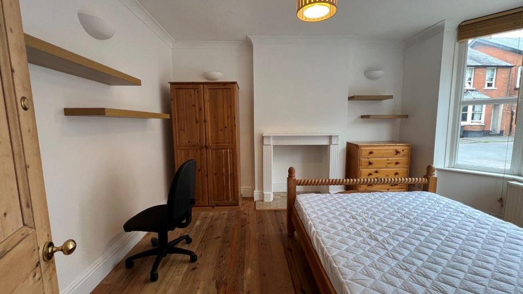 Bright bedroom with wooden furniture and desk a...
