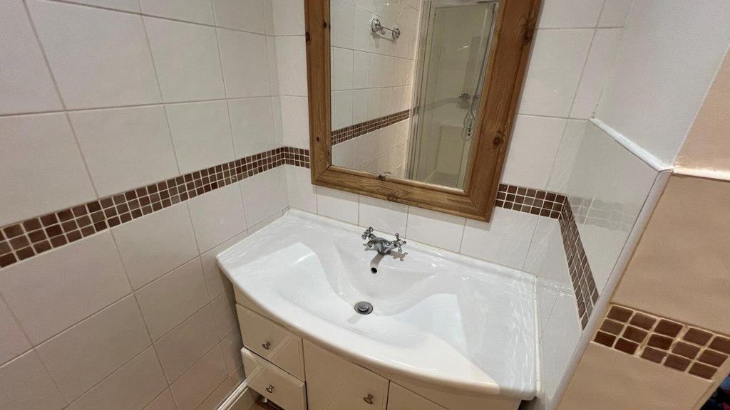 Bright bathroom sink with framed mirror...