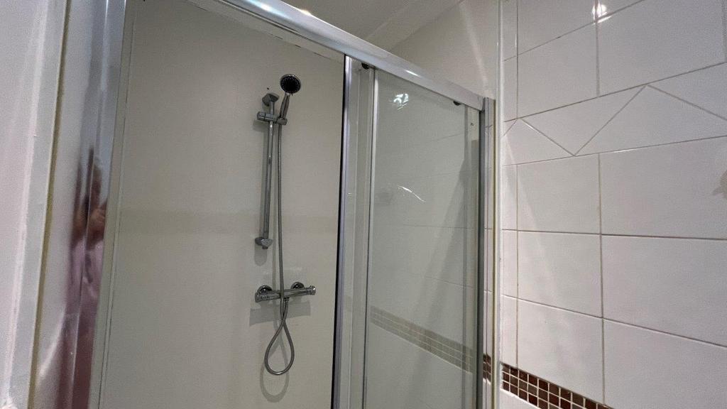 Modern tiled shower with glass sliding door...