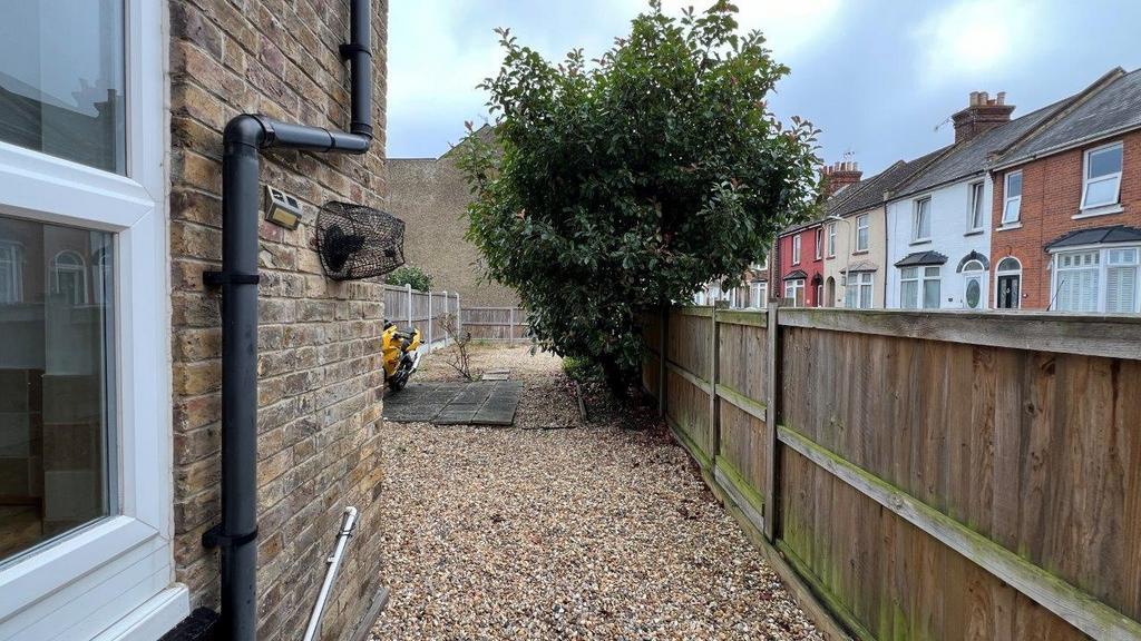 Low-maintenance gravel side yard with gated acc...