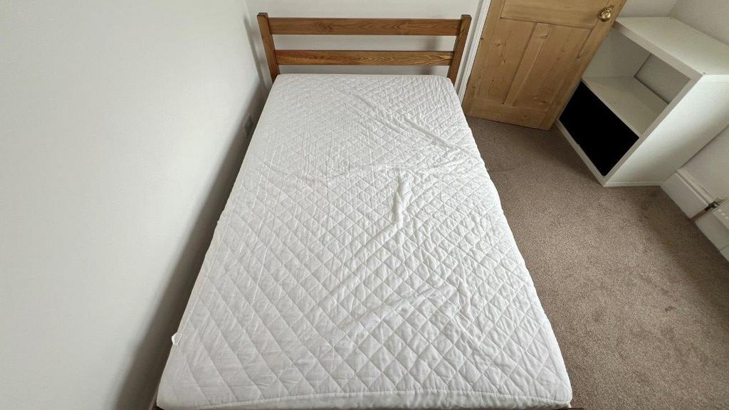 Simple single bed with bedside storage and natu...