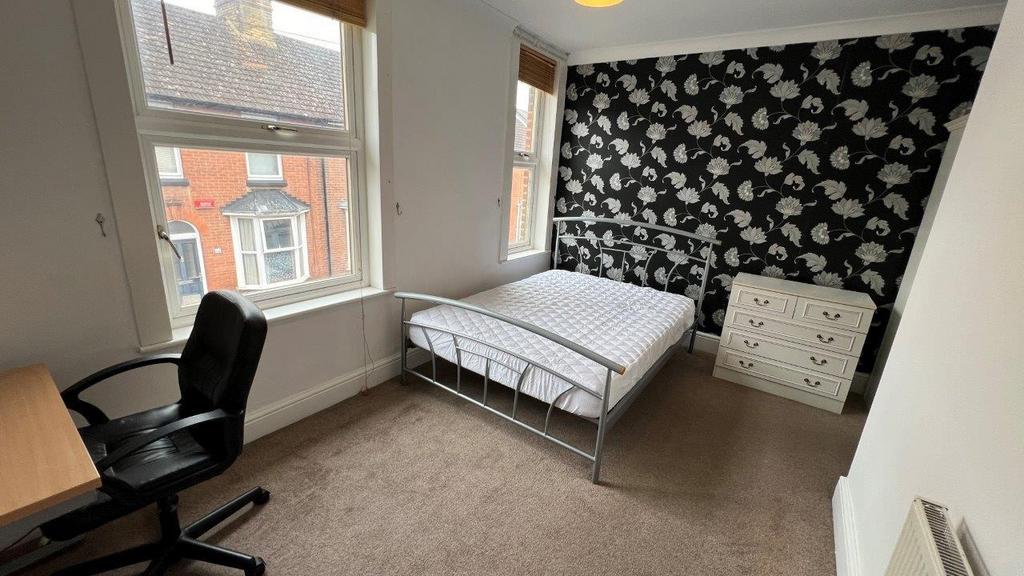 Bright double room with patterned feature wall...