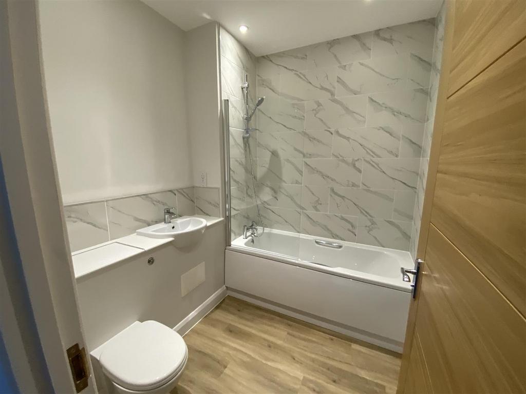 Elegant marble-tiled bathroom with full bathtub...