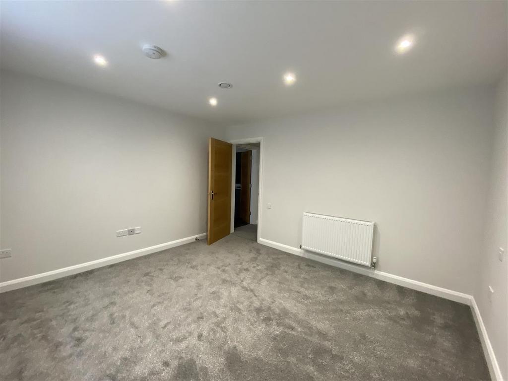 Spacious modern bedroom with plush grey carpet...