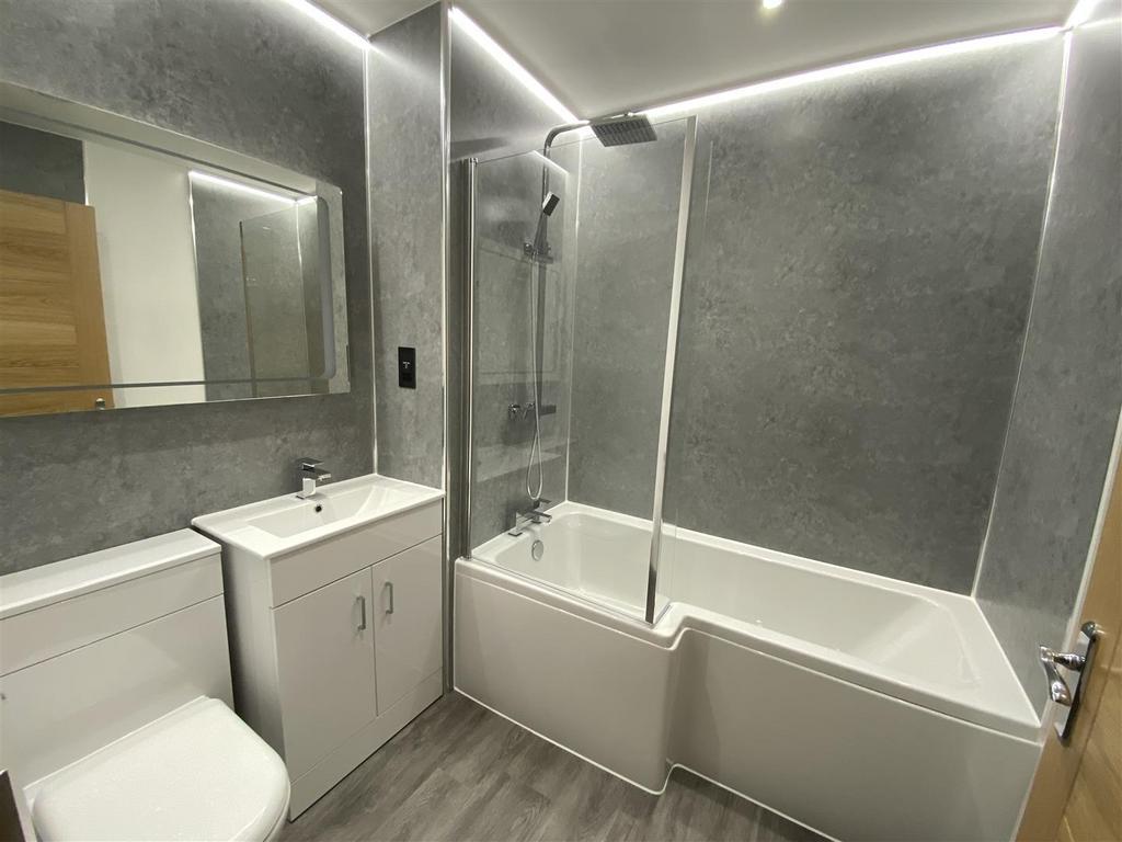Modern bathroom suite with sleek grey tiling...