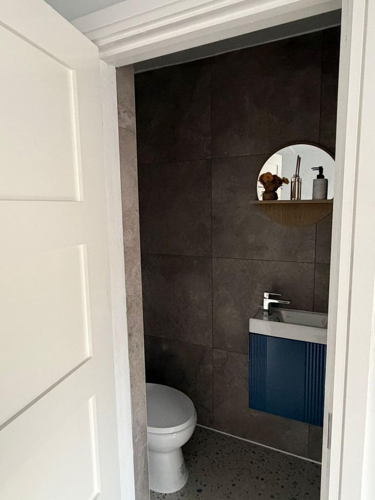 Modern toilet with sleek grey tiles and vanity...