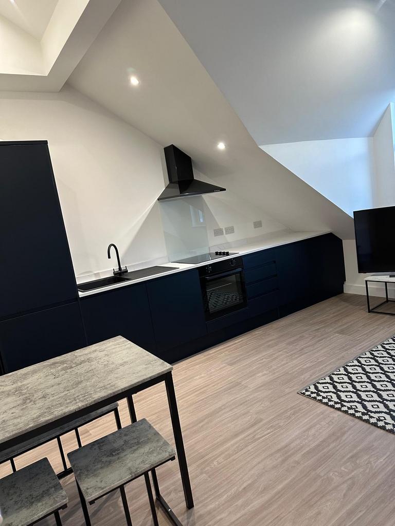 Modern open-plan kitchen with matte dark cabine...