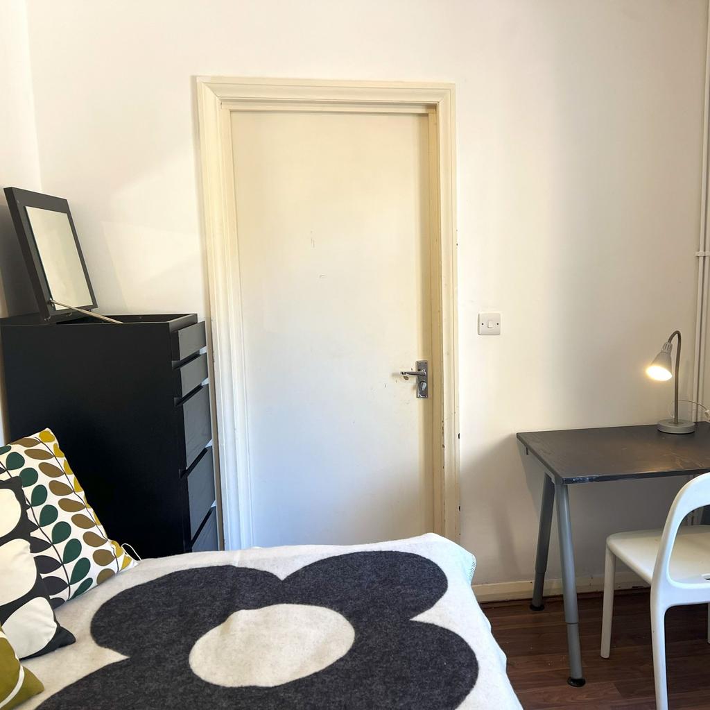 Neat, simply furnished bedroom with a patterned...