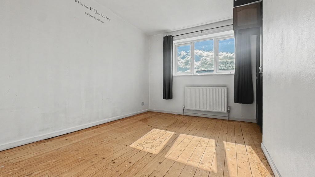 Bright double bedroom with natural wood floors...