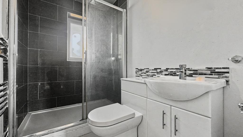 Modern shower room with sleek tiled feature wal...