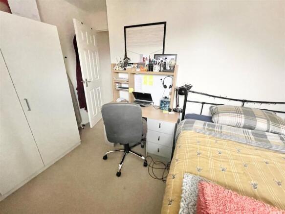 Bright, simply furnished bedroom with a comfort...