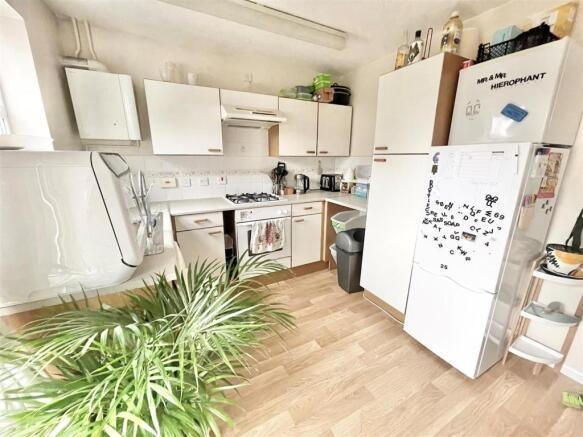 Bright, well-lit kitchen with white cabinetry, ...