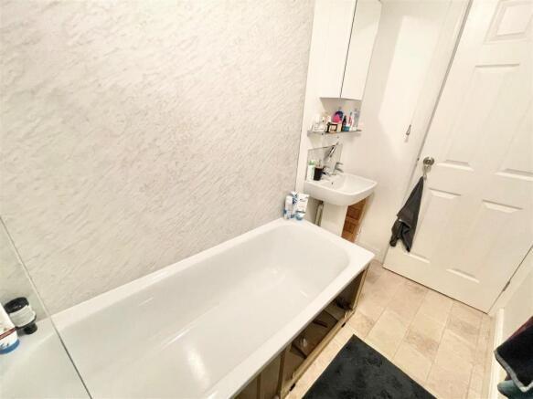 Well-kept bathroom with a clean white bathtub, ...