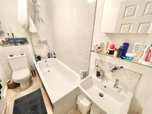 Bright, modern bathroom with a white bath, wall...