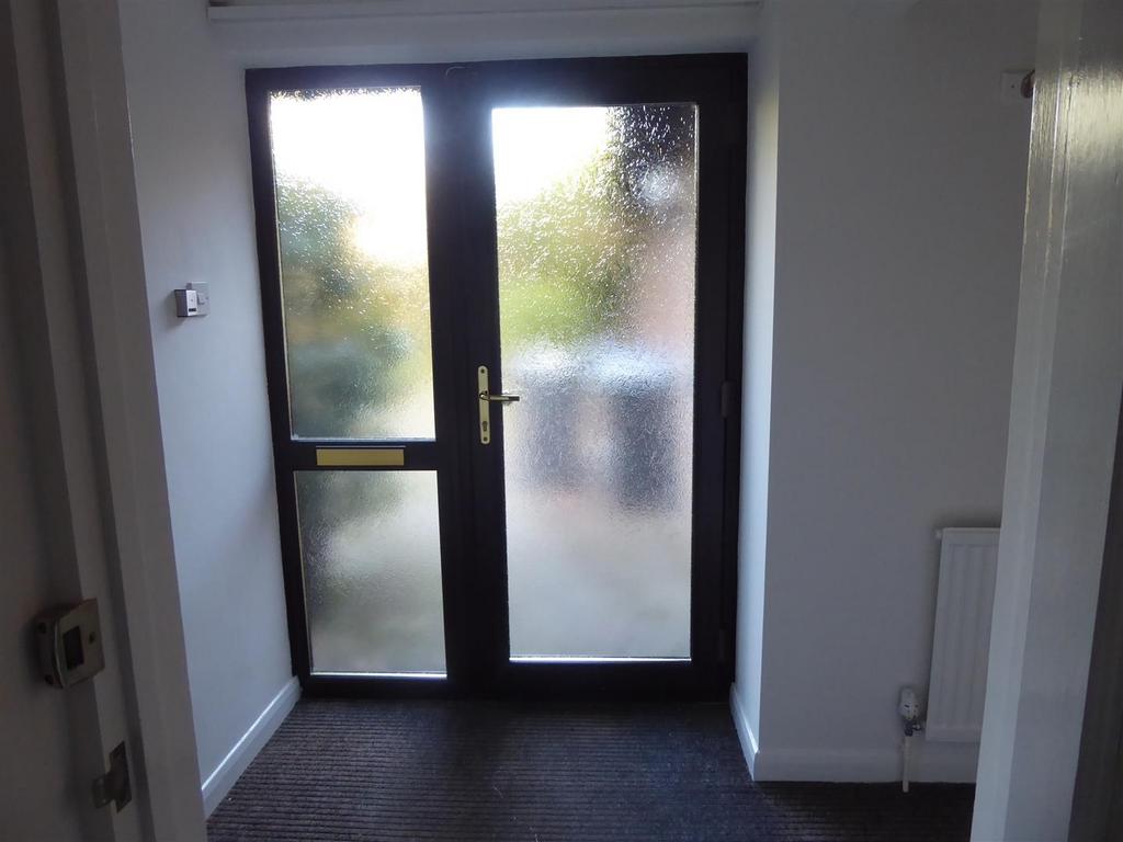Bright, modern entryway with frosted glass door...