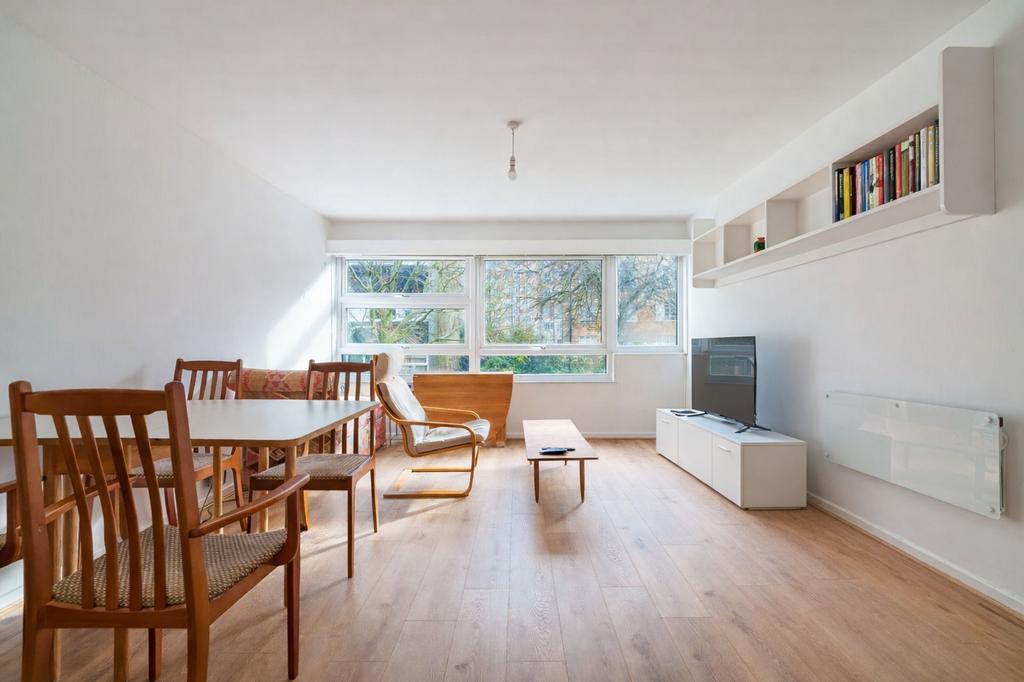 Bright and spacious living room with tree-lined...