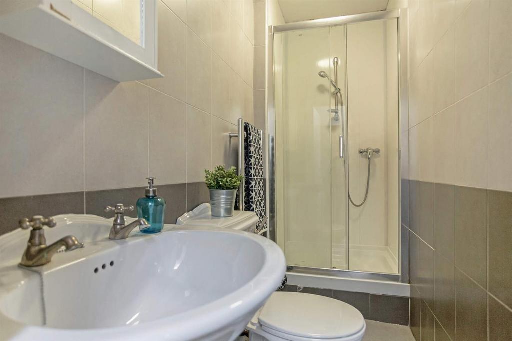 Neat, modern bathroom with a pedestal basin, ti...