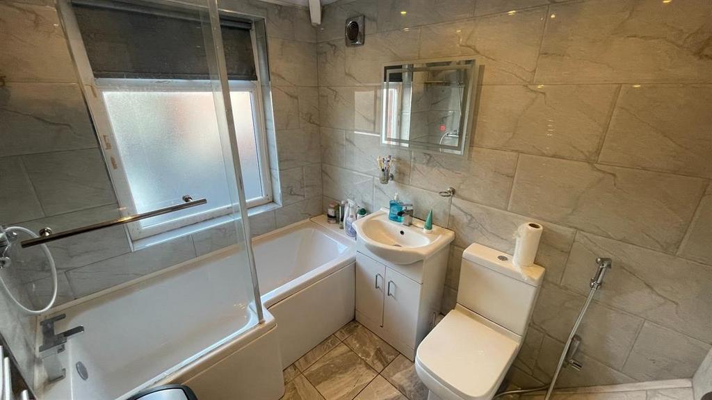 Modern tiled bathroom with a sleek bathtub...