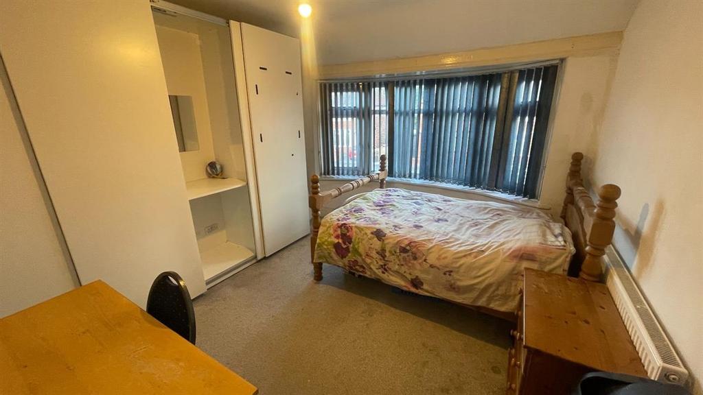 Bright bedroom with large bay window and storag...