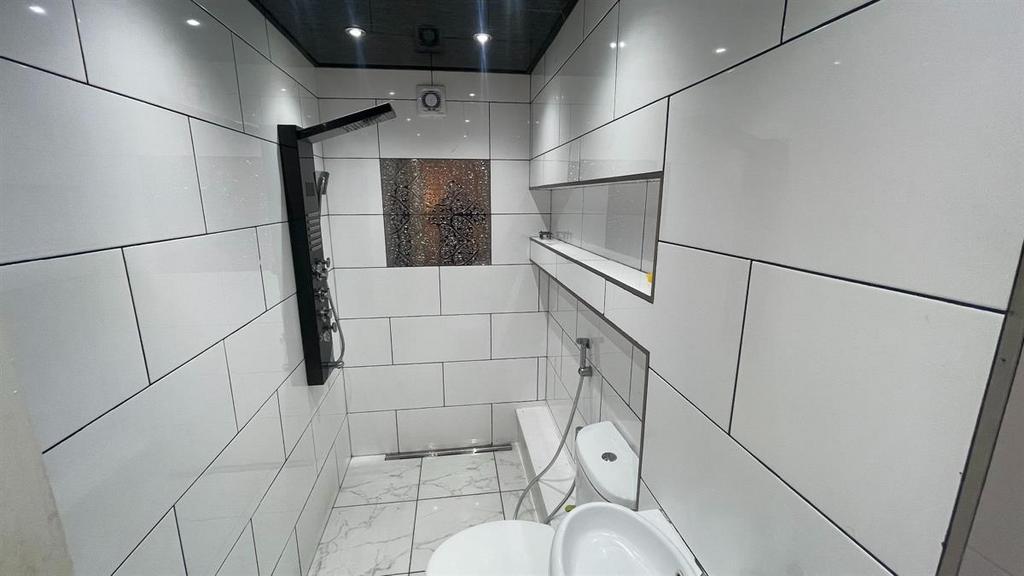 Modern walk-in shower with sleek white tiling...