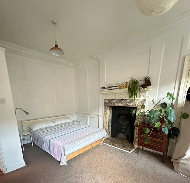 Spacious bright bedroom with character fireplac...