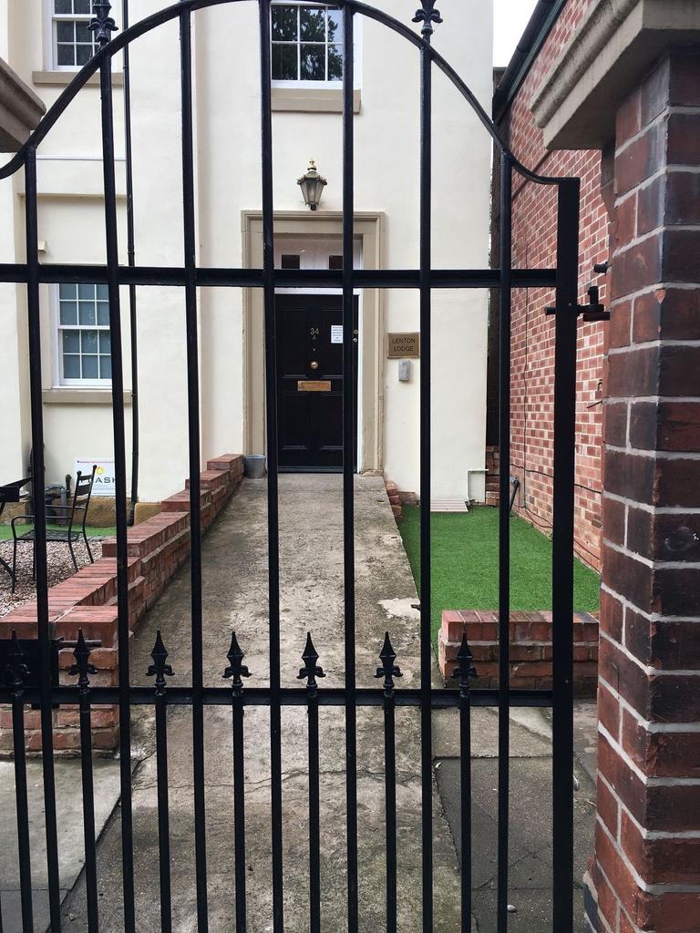 Gated entrance leading to a classic front door ...