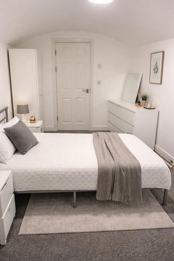 Bright, neatly styled double bedroom with a whi...