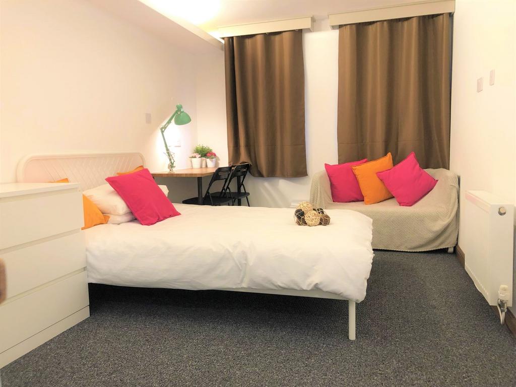A cozy single bedroom featuring a neatly made b...