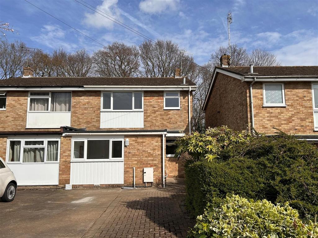 Semi‑detached house with driveway and hedge...