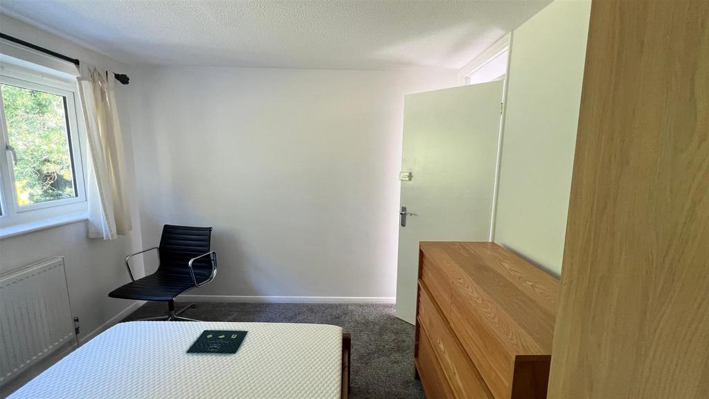 Bright bedroom with bed, desk and storage...