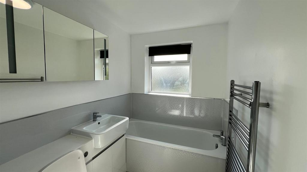 Clean modern bathroom with bath and vanity...