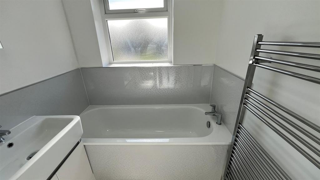 Modern bath with towel radiator and frosted win...