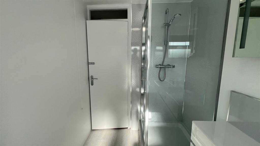 Bright modern bathroom with glass shower...