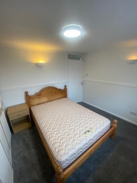 Bright, simple bedroom with double bed and beds...