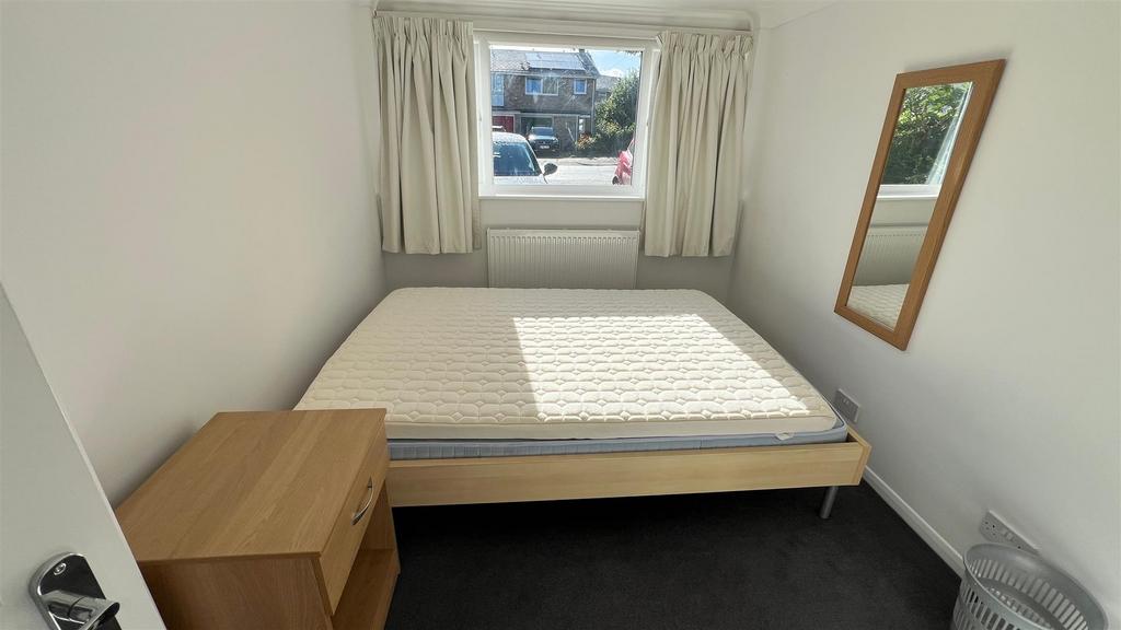 Bright, simply furnished bedroom with double be...
