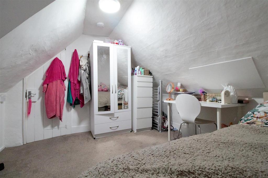Cozy attic bedroom with desk and storage...