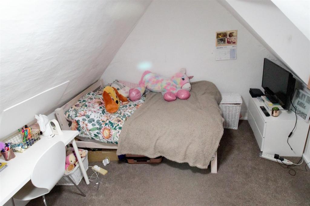 Cozy attic bedroom with desk and TV...