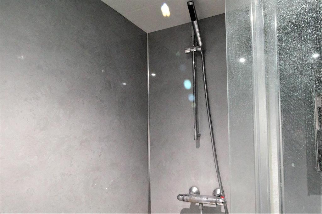 Modern tiled shower with glass screen and chrom...