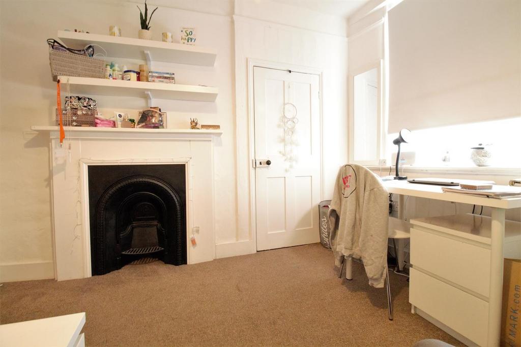 Bright bedroom with desk, shelving and fireplac...