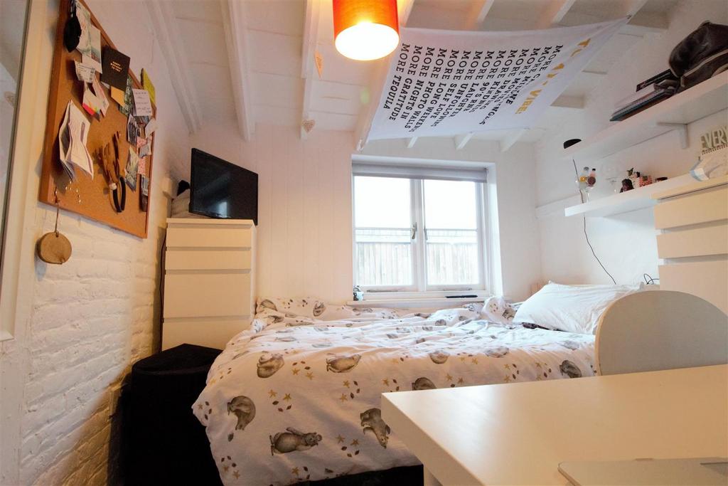 Bright, cozy bedroom with built-in shelving...