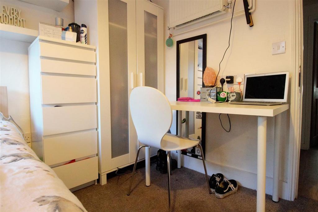 Bright, furnished bedroom with desk and storage...