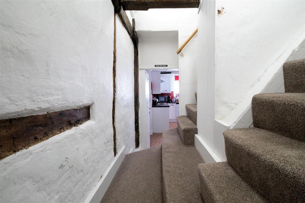 Bright hallway with exposed beams and carpeted ...