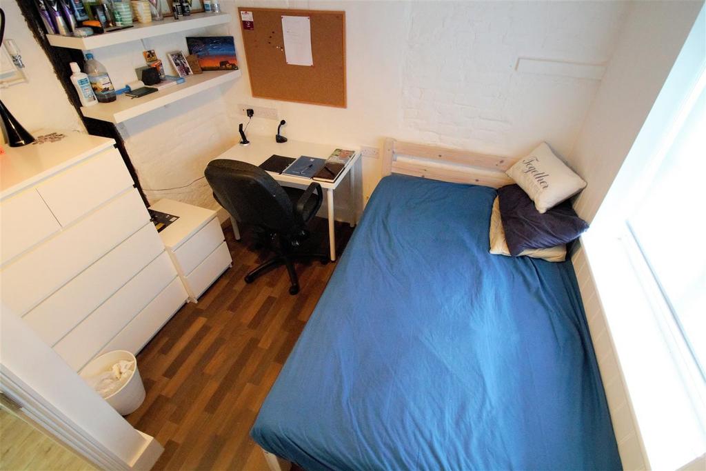 Cozy single room with desk and built‑in storage...