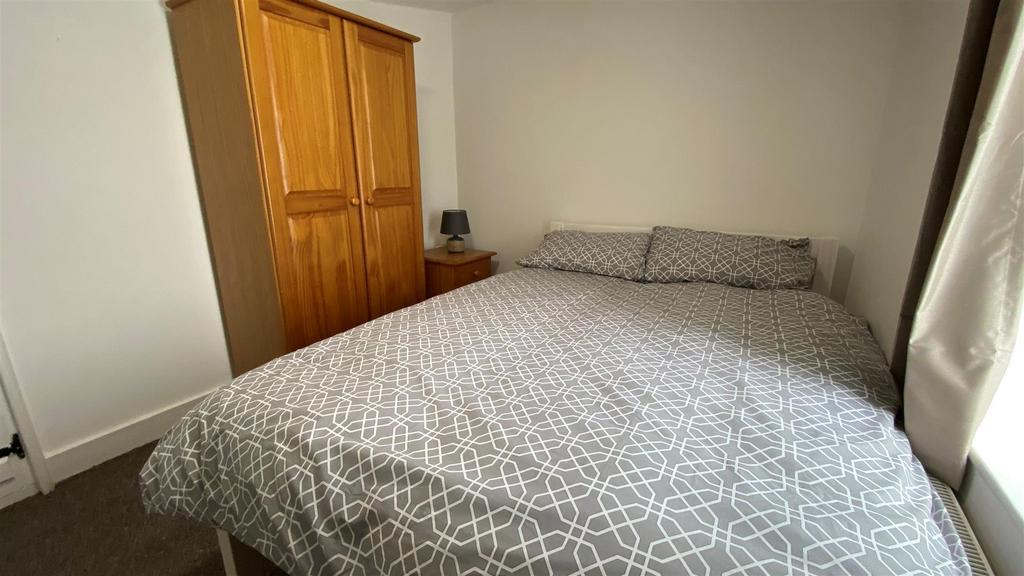 Bright double bedroom with wardrobe and bedside...