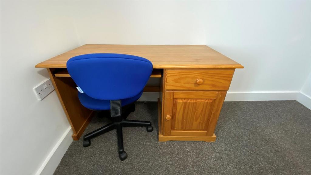 Desk and chair in a tidy carpeted room...