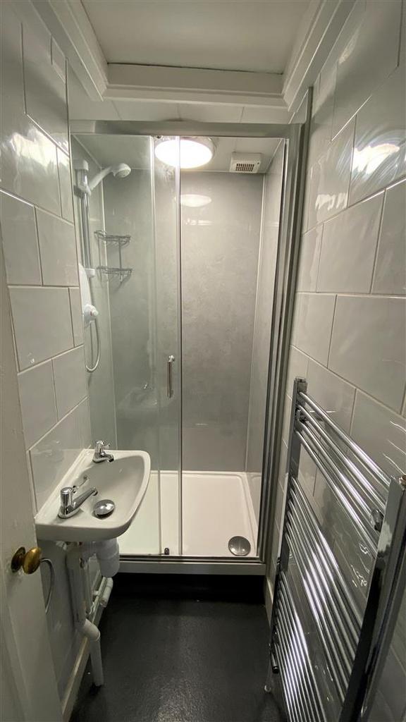 Bright compact bathroom with modern shower...