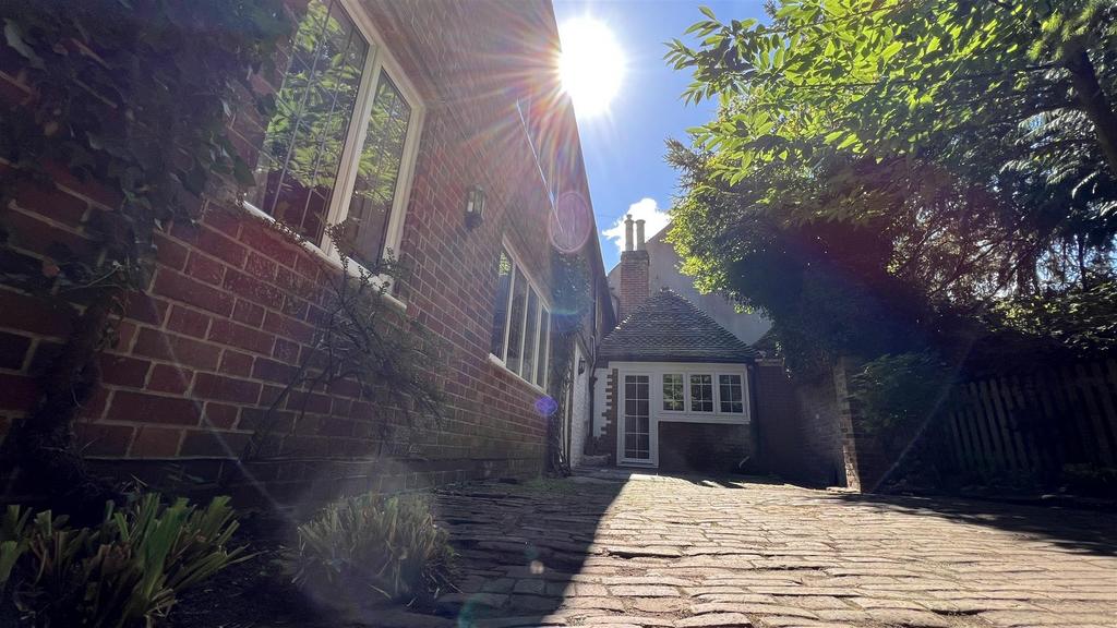 Sunny brick front with paved courtyard and matu...
